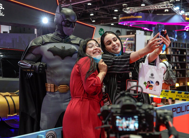 Women take a selfie with the Batman statue.