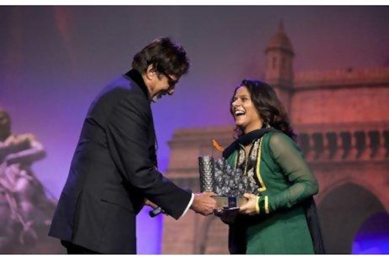 Amitabh Bachchan presents the best actress award to Vibhawari Deshpande for her role in Harishchandrachi Factory in Dubai yesterday.
