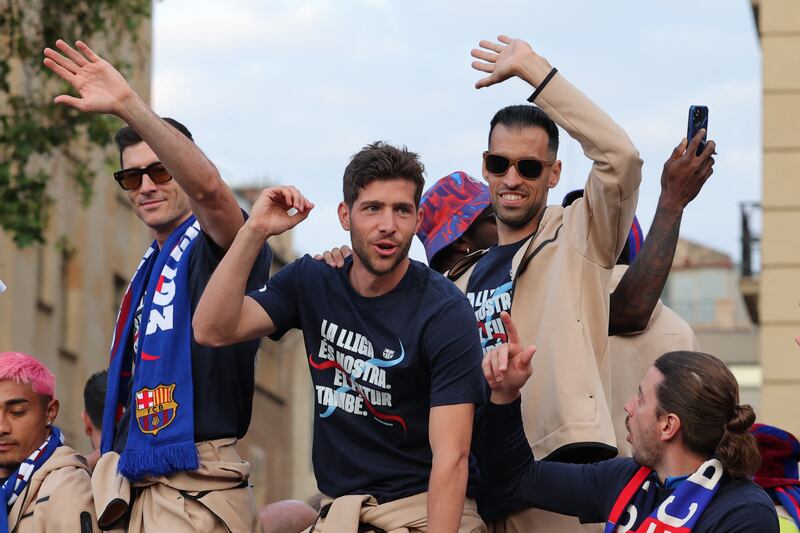 Barcelona's Polish forward Robert Lewandowski, and Spanish midfielders Sergi Roberto and Sergio Busquets wave. AFP