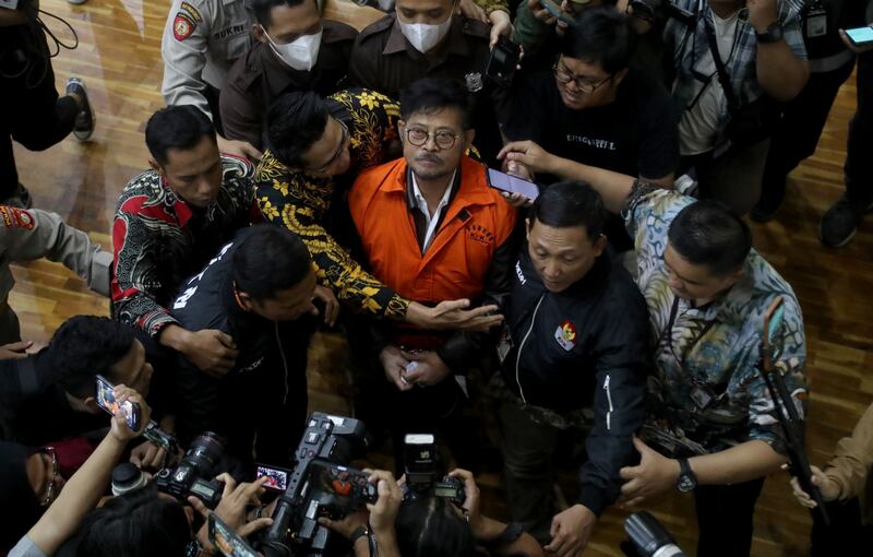 Former Indonesian agriculture minister Syahrul Yasin Limpo, centre, is escorted by anti-corruption officers after his arrest in Jakarta.   EPA 