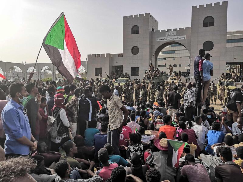 Sudanese soldiers stand guard on armoured military vehicles as demonstrators continue their rally. AFP