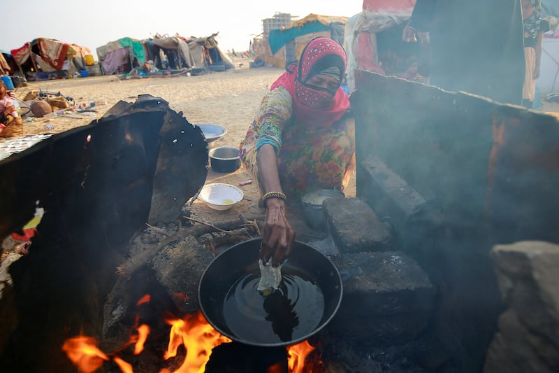 A woman cooks a meal at a camp for displaced people in Al Ghaidha.