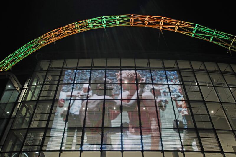Wembley Stadium's arch is lit up in the colours of Brazil and displays the famous photo of Pele with Bobby Moore. PA