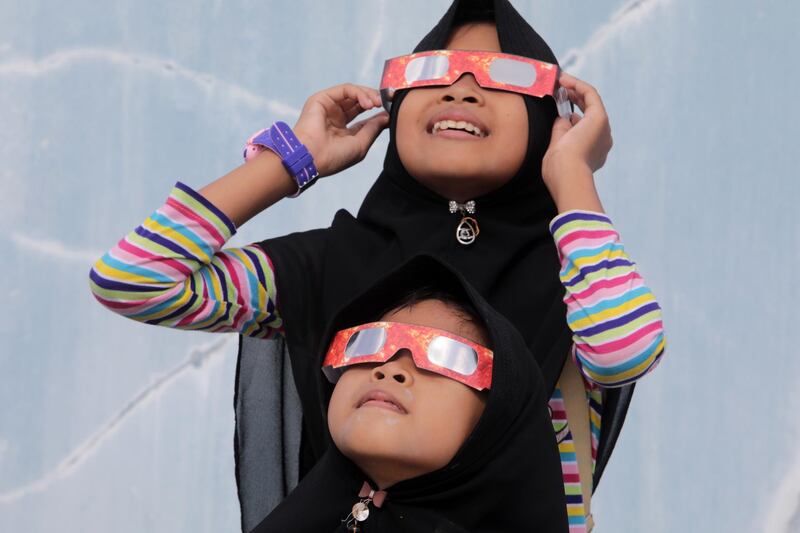 People wear special glasses to look at a solar eclipse in Banda Aceh, Indonesia. The solar eclipse was visible in Saudi Arabia, Qatar, the United Arab Emirates (UAE), Oman, India, Sri Lanka, Singapore, Malaysia and parts of the Indian and Pacific Oceans.  EPA