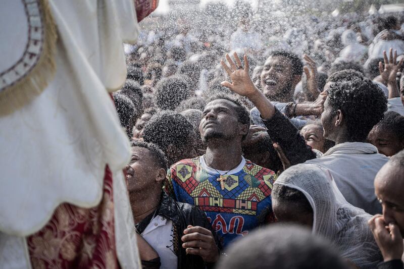 Holy water is sprayed in the faces of Ethiopian Orthodox Christian worshippers during Timkat Epiphany celebrations in Addis Ababa. AFP
