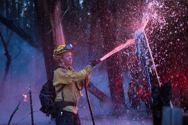 A firefighter douses flames near Aromas, California. AP