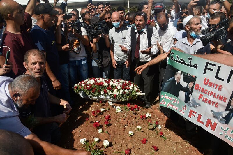 Algerians place roses on the tomb of former president Abdelaziz Bouteflika during his funeral at the El Alia cemetery in the capital Algiers. AFP