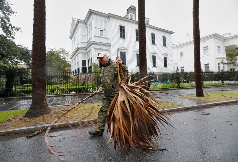 A local resident hauls debris from the road in an effort to keep gutter drains clear as Hurricane Ian bears down on Charleston. Reuters