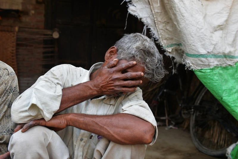 The father of one of two gang-rape victims covers his face as he mourns in Katra Shahadatgunj in Badaun in India's Uttar Pradesh state yesterday. Chandan Khanna / AFP

