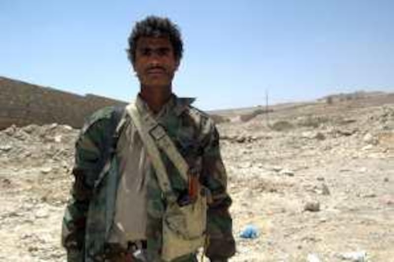 Naser Yahia Dhawi, 20, stands at al Jabal al Aswad military camp in Harf Sufian in the north, holding a dagger and a book of the holy Quran which he alleged he obtained from slaughtered al Houthi rebels during their warfare. About 400 tribal fighters are backing the army in its offensive against the insurgency in the north since August 11.Mohammed al Qadhi/The National