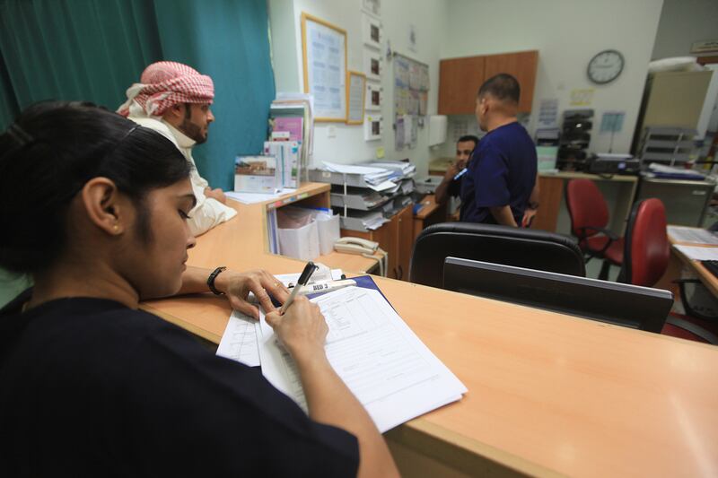 Minimol Nair, left, prepares a case sheet for a patient in the emergency unit at Al Noor hospital in Abu Dhabi. Ravindranath K / The National