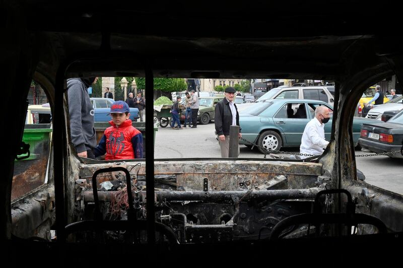 Lebanese people inspect a burnt out car of the Lebanese Internal Security Forces which was set ablaze by protesters in Tripoli, northern Lebanon.  EPA