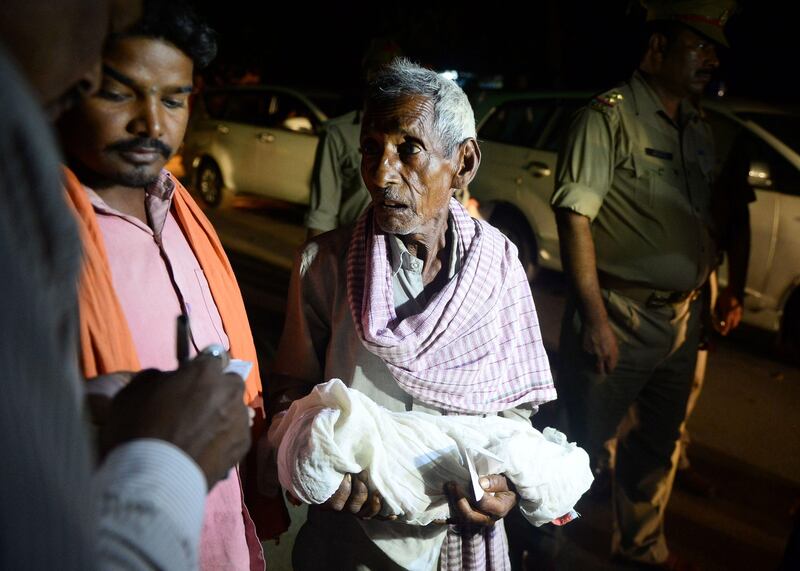 An Indian relative mourns as he carries a dead child outside the Baba Raghav Das Hospital in Gorakhpur, in the northern Indian state of Uttar Pradesh late August 12, 2017. 
At least 60 children have died over five days at a government hospital in northern India that suffered oxygen shortages, officials said August 12 amid fears the toll could rise. Authorities said they have launched an inquiry but denied reports that a lack of oxygen had caused the deaths at the Baba Raghav Das Hospital in Gorakhpur district in Uttar Pradesh state, which is ruled by Prime Minister Narendra Modi's Bharatiya Janata Party. / AFP PHOTO / SANJAY KANOJIA