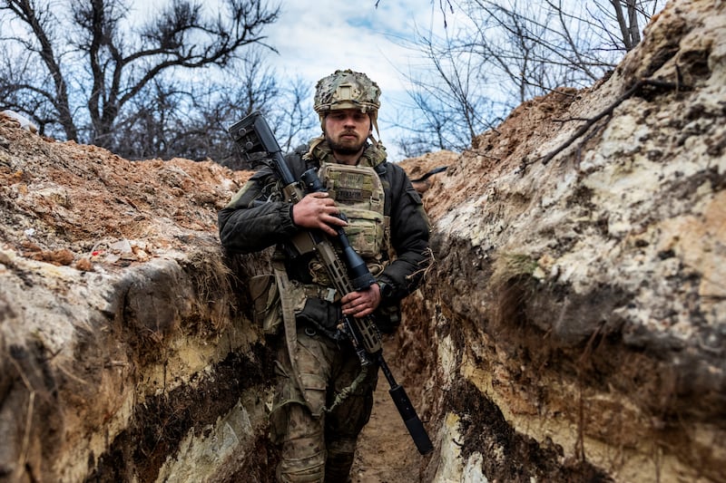 A Ukrainian sniper with the 28th Brigade moves to a fighting position in a front-line trench facing Russian troops in March 2023 outside of Bakhmut. Getty Images