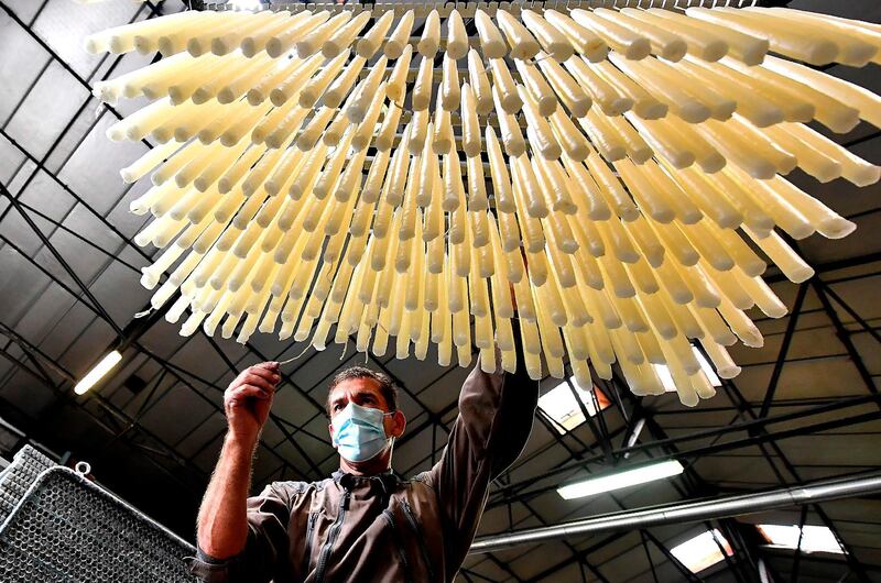 An employee controls the quality of the wicks of the candles in the workshops of the Ciergerie de Lourdes in Lourdes, France. AFP