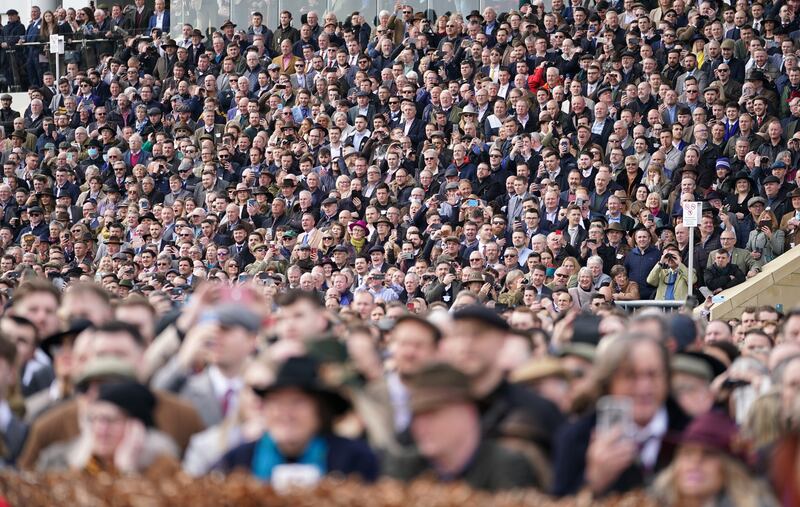 Crowds watch the action during day one of the Cheltenham Festival. PA