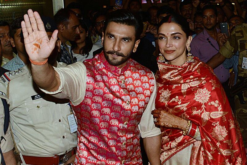 Bollywood actors and recently-wedded couple Ranveer Singh (L) and Deepika Padukone acknowledge fans gathered at the Mumbai international airport early on November 18, 2018, following their return from their nuptials at Italy's Lake Como.  Photo / AFP