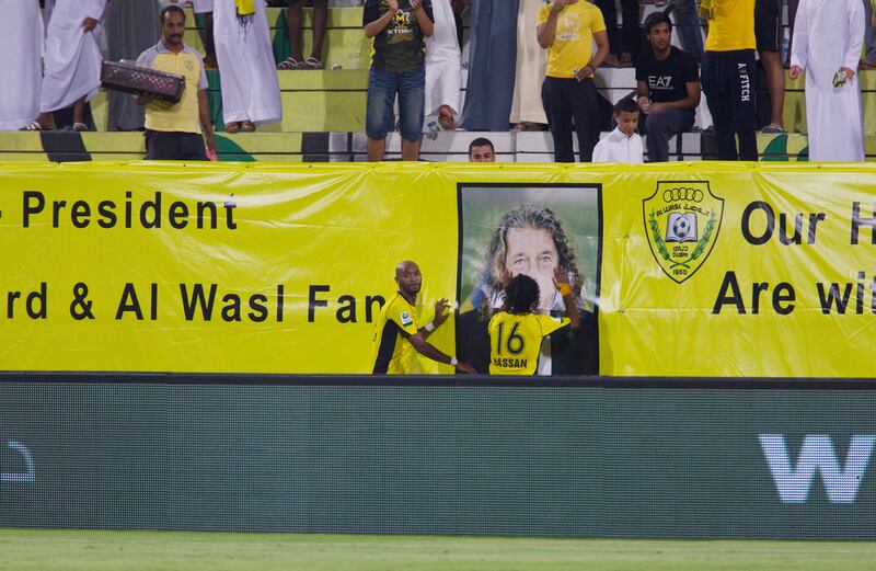 Dubai, United Arab Emirates, October 28, 2012:   Al Wasl's Mahmoud Abdeirazek, left, and Hassan Ali touch a banner wishing well ailing head coach Bruno Metsu while celebrating his goal with team mate  during the first half of their Pro League match at Zabeel Stadium in Dubai on October 28, 2012. Christopher Pike / The National