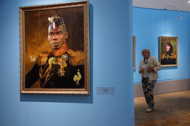 A visitor walks among portraits including France's Paul Pogba, left, at the Museum of Academy of Arts in St.Petersburg, Russia. Dmitri Lovetsky / AP Photo