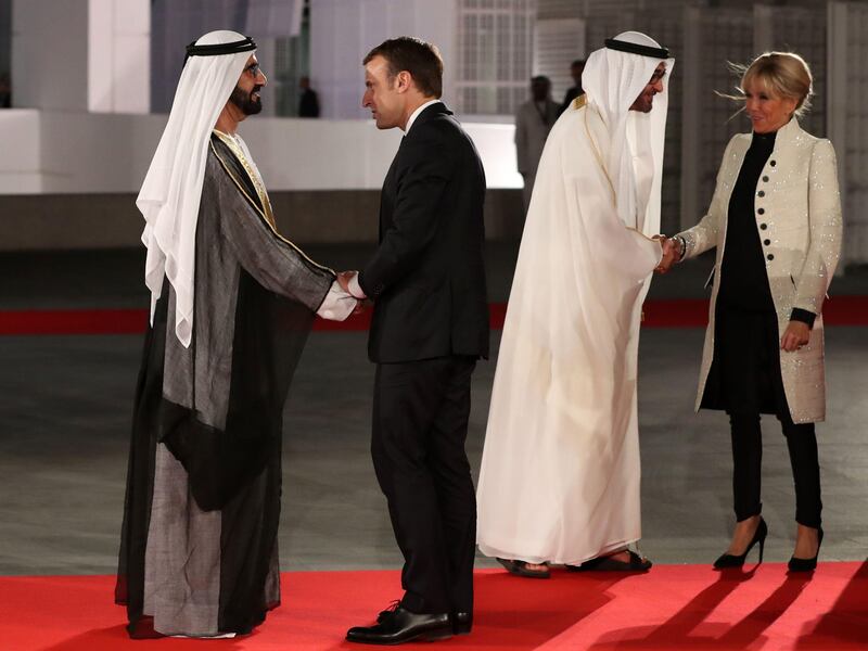 Sheikh Mohammed bin Rashid, UAE Vice President and Ruler of Dubai shakes hands with French president Emmanuel Macron as Sheikh Mohammed bin Zayed, Crown Prince of Abu Dhabi and Deputy Supreme Commander of the UAE Armed Forces greets the president's wife, Brigitte Macron, at the formal opening Louvre Abu Dhabi. Karim Sahib / AFP Photo