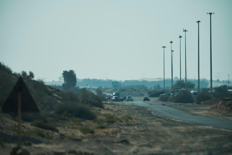 Police, ambulances and crash-site investigation vehicles are seen near the site of a small plane crash in Dubai, United Arab Emirates, Friday, May 17, 2019. A small plane involved in upgrading a runway at Dubai International Airport crashed Thursday night, killing four people and halting traffic at the world's busiest airport for international travel for nearly an hour. (AP Photo/Jon Gambrell)