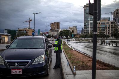BEIRUT, LEBANON - JANUARY 14: A Police officerÂ checks the documents of a taxi driver on the first day of the 24 hours lockdown on January 14, 2021, in Beirut, Lebanon. The country is introducing an 11-day, 24-hour curfew that confines people to their homes with limited exceptions. Residents will even be banned from going to the grocery store. (Photo by Diego Ibarra Sanchez/Getty Images)