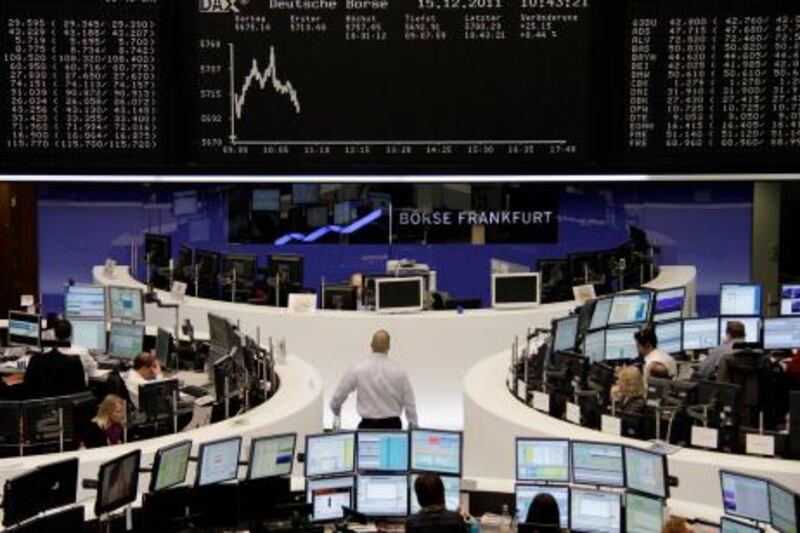 Traders are pictured at their desks in front of the DAX board at the Frankfurt stock exchange December 15, 2011. REUTERS/Remote/Amanda Andersen   (GERMANY - Tags: BUSINESS) *** Local Caption ***  BER601_GERMANY-_1215_11.JPG