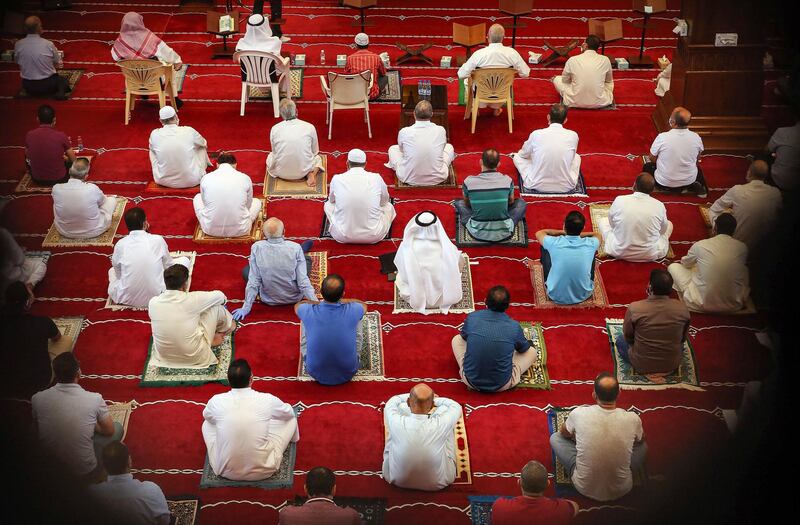 Worshippers, distanced safely from each other and clad in face masks, attend a sermon during the Friday prayers at a mosque in Kuwait City. AFP