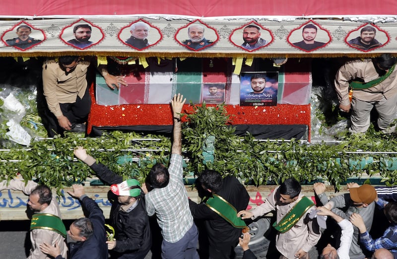 A mourner touches the coffin of one of the slain members of the IRGC. EPA
