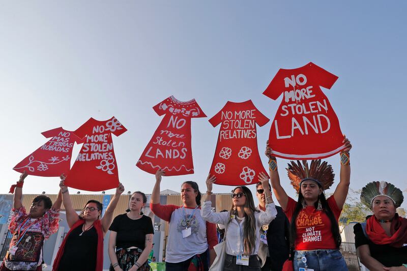 Placards bearing slogans in Spanish and English are held aloft in the Red Sea resort city. AFP