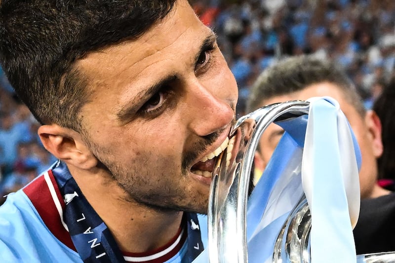 Manchester City's Spanish midfielder #16 Rodri bites the European Cup trophy as they celebrate winning the UEFA Champions League final football match between Inter Milan and Manchester City at the Ataturk Olympic Stadium in Istanbul. AFP
