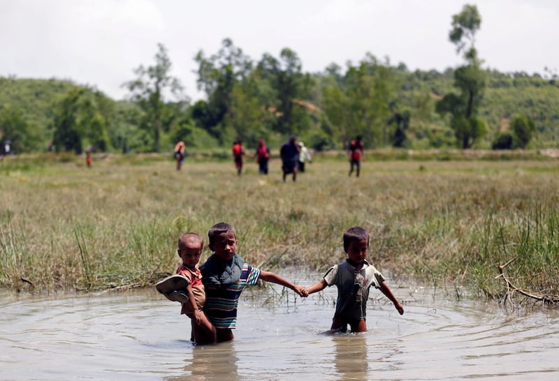 Rohingya children make their way through water as they try to come to the Bangladesh side from No Man’s Land after a gunshot being heard on the Myanmar side, in Cox’s Bazar, Bangladesh August 28, 2017. REUTERS/Mohammad Ponir Hossain     TPX IMAGES OF THE DAY