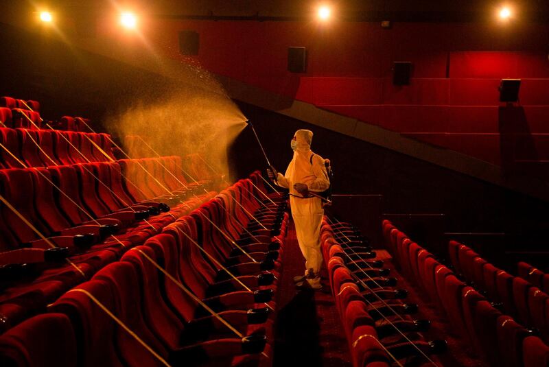 A worker disinfects a movie theatre before its reopening to the public in the southern Iraqi city of Basra, following an easing of restrictions imposed by the authorities in a bid to stem the spread of the novel coronavirus.  AFP