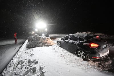 Snow is cleared with wheel loaders as vehicles are recovered and people evacuated on the E22 between Horby and Kristianstad in southern Sweden. AP