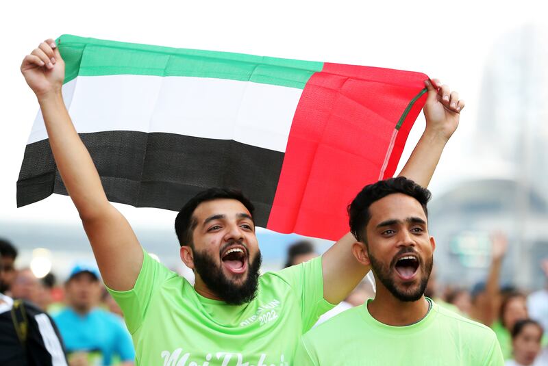 Participants proudly display the UAE flag during Dubai Run 2022