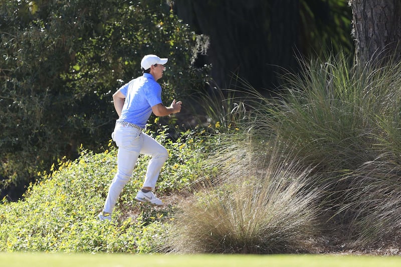 McIlroy looks for his ball on the tenth hole. AFP