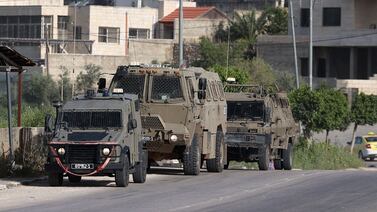 Israeli vehicles are positioned at the entrance of the Nur Shams Palestinian refugee camp near the northern West Bank town of Tulkarm on April 10, 2021. AFP