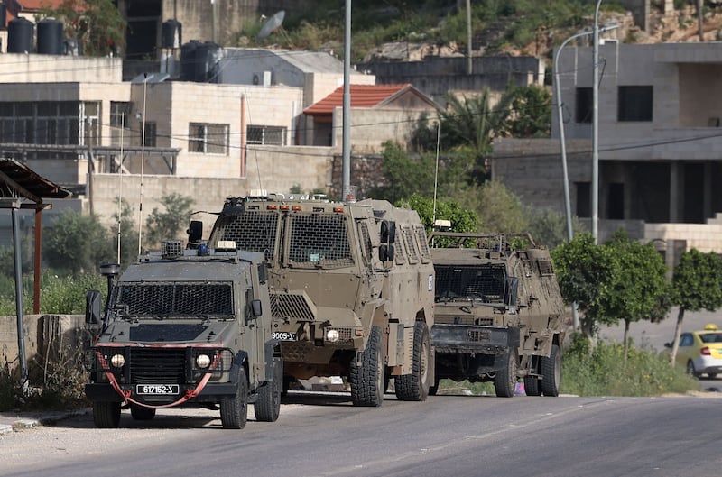 Israeli vehicles are positioned at the entrance of the Nur Shams Palestinian refugee camp near in the northern West Bank town of Tulkarem on April 10,2022l, during a raid looking for suspects related to a gunman from Jenin who went on a shooting rampage in a popular Tel Aviv nightlife area on April 7, killing three Israelis and wounding more than a dozen others.  (Photo by JAAFAR ASHTIYEH  /  AFP)
