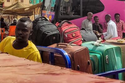A man on a motorcycle loaded with suitcases as people prepare to leave on buses from southern Khartoum this week.  AFP