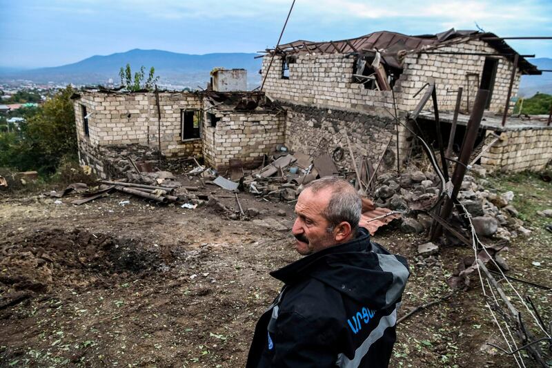 Ashot Aghajanian, 54, stands in the yard of his house destroyed by shelling in Stepanakert.  AFP