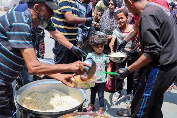 Palestinians receive meals from World Central Kitchen in Deir Al Balah. Reuters 