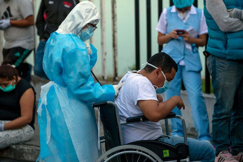A health worker checks a patient with symptoms related to Covid-19 at the coronavirus unit of the San Juan de Dios Hospital in Guatemala City. AP Photo