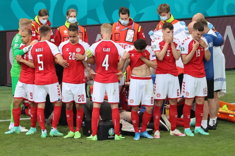 Denmark's players make protective shield as paramedics attend to midfielder Christian Eriksen. AFP