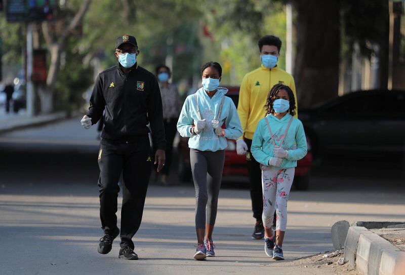A family takes a walk while wearing face masks in the upmarket neighbourhood of Zamalek in Cairo. Reuters
