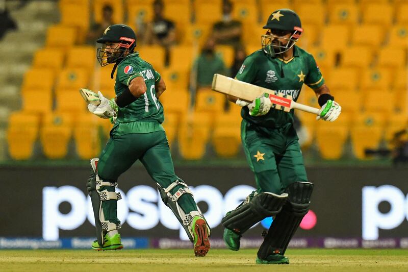 Pakistan's wicketkeeper Mohammad Rizwan (L) and Babar Azam run between the wickets during the ICC men’s Twenty20 World Cup cricket match between Namibia and Pakistan at the Sheikh Zayed Cricket Stadium in Abu Dhabi on November 2, 2021.  (Photo by INDRANIL MUKHERJEE  /  AFP)