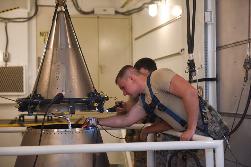 Airmen inspect an intercontinental ballistic missile during a test at a launch facility. AP