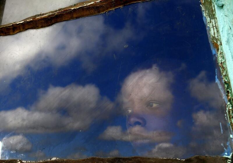 A local boy, Anda, looks out from a window at the burial ground of late former South African President Nelson Mandela ahead of his funeral in Qunu. Yannis Behrakis / Reuters
