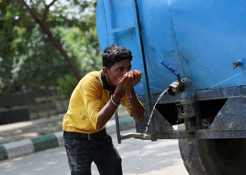 A labourer drinks water from a tanker at a construction site on a hot summer day in Noida. India is experiencing a heatwave in the northern and western parts of the country. Reuters