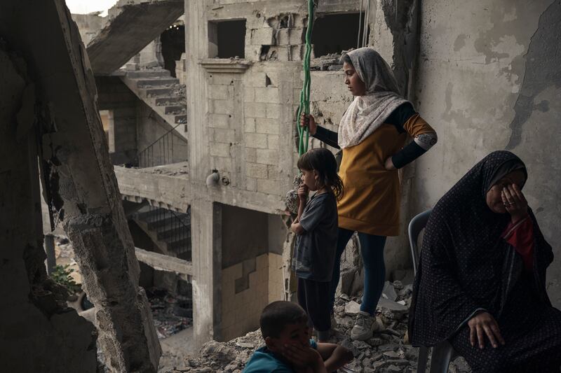 Members of the Nassir family sit inside their home. More than 2,000 homes were destroyed and thousands more damaged by Israeli air strikes in the Gaza Strip. AP