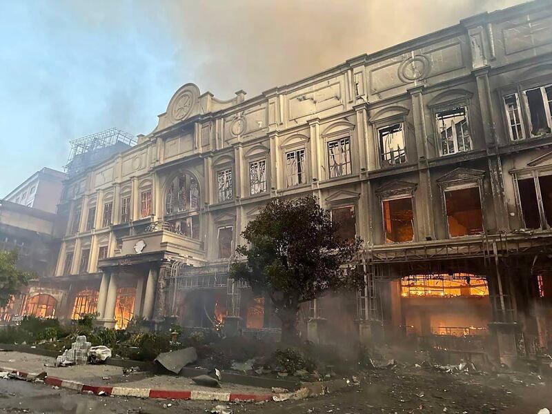 In this photo provided by Cambodia's Fresh News, a building burns near a Cambodia-Thai international border gate in Poipet, west of Phnom Penh, Cambodia, Wednesday, Dec.  28, 2022.  A fire burning through the Grand Diamond City Casino and Hotel has killed multiple people and injured dozens of others, police said Thursday, and neighboring Thailand sent firetrucks to help fight the blaze in a bustling border region.  (Fresh News via AP)